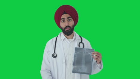 Triste-Médico-Indio-Sikh-Explicando-El-Informe-De-Rayos-X-A-La-Pantalla-Verde-Del-Paciente