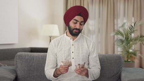 Happy-Sikh-Indian-man-counting-money