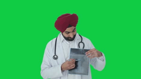 Happy-Sikh-Indian-doctor-explaining-X-ray-report-to-patient-Green-screen