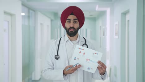 Médico-Indio-Sikh-Enojado-Explicando-Informes-Médicos-Al-Paciente
