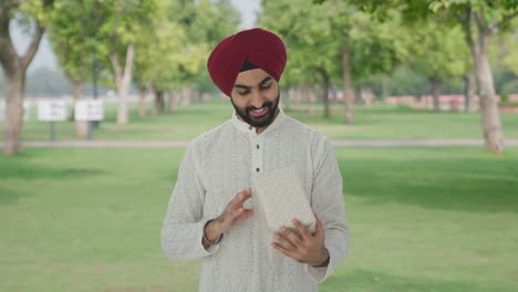 Glücklicher-Sikh-Indianer,-Der-Im-Park-Ein-Geschenk-Erhält