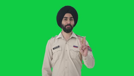 Fröhlicher-Indischer-Sikh-Polizist-Zeigt-Siegeszeichen-Auf-Grünem-Bildschirm