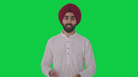 Ernsthafter-Sikh-Indianer,-Der-Mit-Dem-Grünen-Bildschirm-Der-Kamera-Spricht