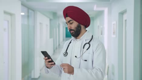 Glücklicher-Indischer-Sikh-Arzt,-Der-Das-Telefon-Scrollt