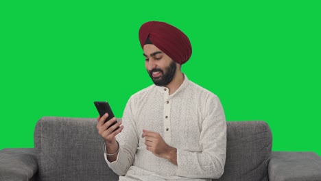 Feliz-Hombre-Indio-Sikh-Desplazándose-Por-La-Pantalla-Verde-Del-Teléfono