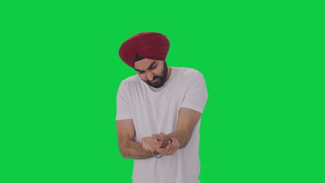 Sick-Sikh-Indian-man-suffering-from-hand-pain-Green-screen