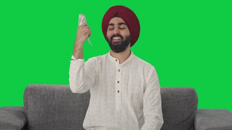 Happy-Sikh-Indian-man-using-money-as-fan-Green-screen