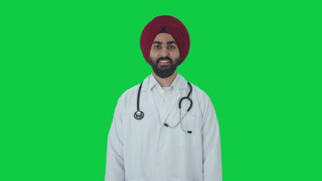 Glücklicher-Indischer-Sikh-Arzt,-Der-Auf-Grünem-Bildschirm-Lächelt