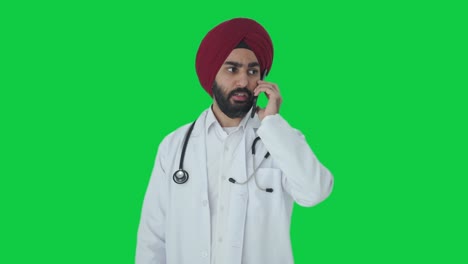 Seriöser-Indischer-Sikh-Arzt,-Der-Auf-Grünem-Bildschirm-Spricht