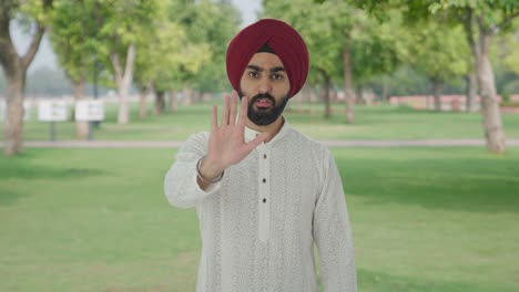 Sikh-Indian-man-stopping-someone-in-park