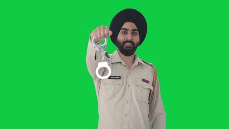 Fröhlicher-Indischer-Sikh-Polizist-Posiert-Mit-Handschellen-Auf-Grünem-Bildschirm