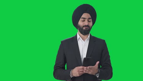 Angry-Sikh-Indian-businessman-texting-someone-Green-screen