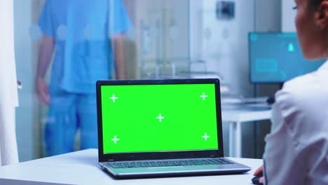 Over-shoulder-footage-of-doctor-using-laptop