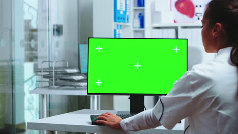 Doctor-sits-at-computer-with-blank-display