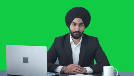 Ernsthafter-Indischer-Sikh-Geschäftsmann,-Der-Jemanden-Auf-Grünem-Bildschirm-Anschaut