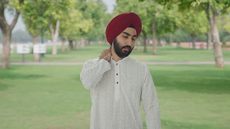 Hombre-Indio-Sikh-Enfermo-Que-Sufre-De-Dolor-De-Cuello-En-El-Parque