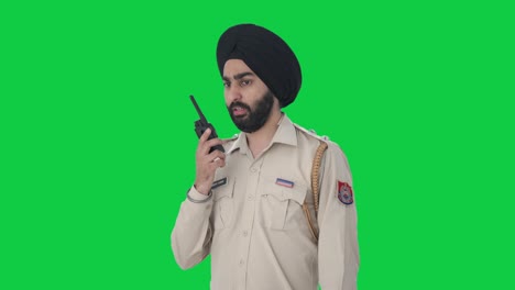 Sikh-Indian-police-man-talking-on-radio-Green-screen