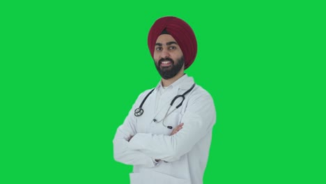 Porträt-Eines-Glücklichen-Indischen-Sikh-Arzts,-Der-Mit-Gekreuzten-Händen-Auf-Grünem-Bildschirm-Steht