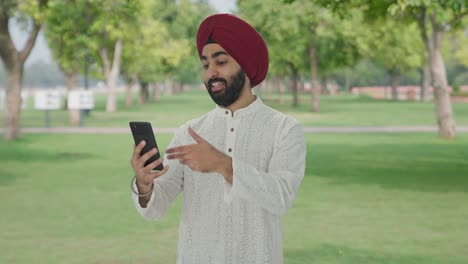 Glücklicher-Sikh-Indianer,-Der-Im-Park-Per-Videoanruf-Spricht