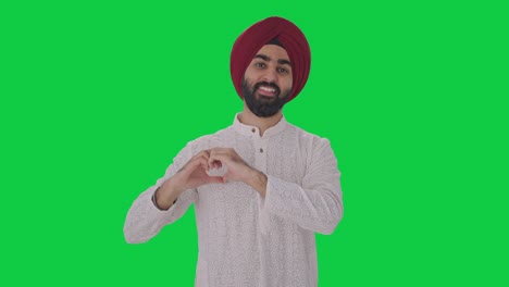 Happy-Sikh-Indian-man-showing-heart-sign-Green-screen