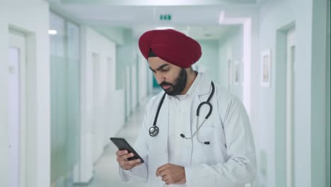 Gestresster-Sikh-indischer-Arzt,-Der-Das-Telefon-Scrollt
