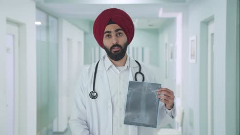 Triste-Médico-Indio-Sikh-Explicando-El-Informe-De-Rayos-X-Al-Paciente
