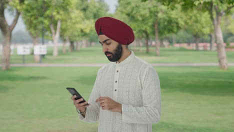 Ernsthafter-Sikh-Indianer,-Der-Im-Park-Telefoniert