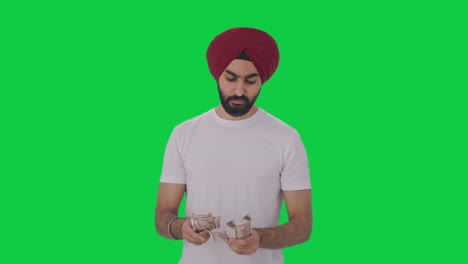 Sikh-Indian-man-counting-money-Green-screen