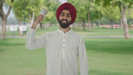Happy-Sikh-Indian-man-using-money-as-fan-in-park