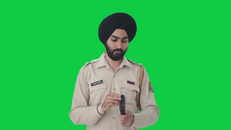 Indischer-Sikh-Polizist-überprüft-Handfeuerwaffe-Auf-Grünem-Bildschirm
