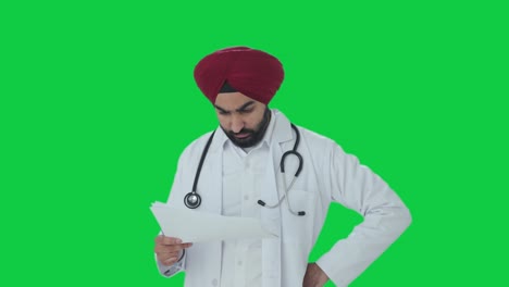 Stressed-Sikh-Indian-doctor-checking-medical-reports-Green-screen