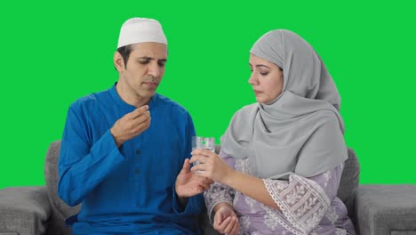 Muslimische-Frau-Gibt-Ihrem-Mann-Medikamente,-Grüner-Bildschirm