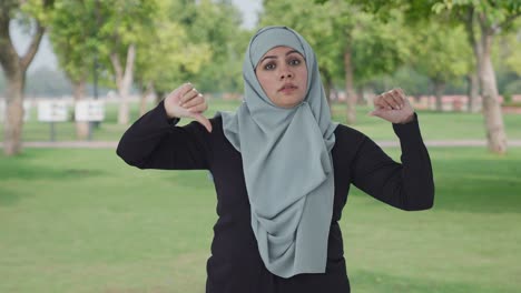 Mujer-Musulmana-Decepcionada-Mostrando-Los-Pulgares-Hacia-Abajo-En-El-Parque