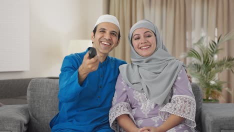 Glückliches-Muslimisches-Paar,-Das-Beim-Fernsehen-Lacht
