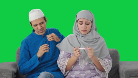 Besorgtes-Muslimisches-Paar-überprüft-Schwangerschaftstest-Auf-Grünem-Bildschirm