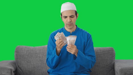 Muslimischer-Mann,-Der-Zu-Hause-Geld-Zählt,-Grüner-Bildschirm