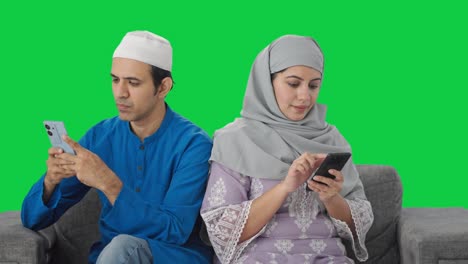 Muslim-couple-busy-on-their-phones-Green-screen