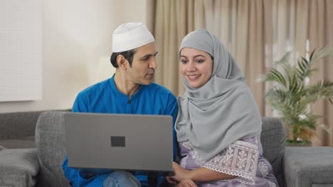 Happy-Muslim-couple-doing-online-shopping-on-laptop