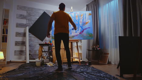 Guy-painting-on-canvas-with-roller