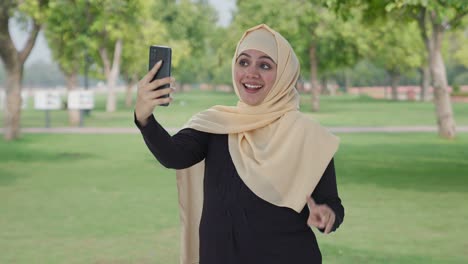 Glückliche-Muslimische-Frau,-Die-Im-Park-Auf-Selfies-Klickt