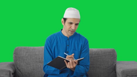 Glücklicher-Muslimischer-Mann,-Der-Etwas-Auf-Grünem-Bildschirm-Schreibt