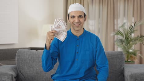 Egoistic-Muslim-man-using-money-as-fan