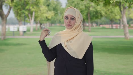 Mujer-Musulmana-Egoísta-Usando-Dinero-Como-Ventilador-En-El-Parque