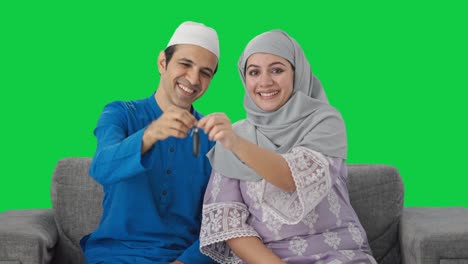 Muslimisches-Paar-Zeigt-Autoschlüssel-Auf-Grünem-Bildschirm-Der-Kamera