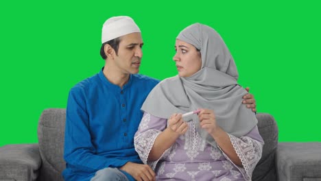 Pareja-Musulmana-Estresada-Comprobando-La-Pantalla-Verde-De-La-Prueba-De-Embarazo