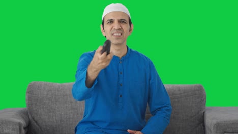 Frustrierter-Muslimischer-Mann,-Der-Versucht,-Den-Grünen-Bildschirm-Der-Fernsehfernbedienung-Zu-Reparieren