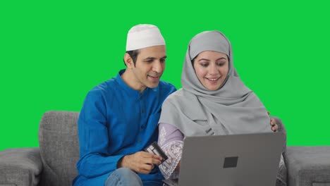 Happy-Muslim-couple-doing-shopping-on-laptop-using-credit-card-Green-screen