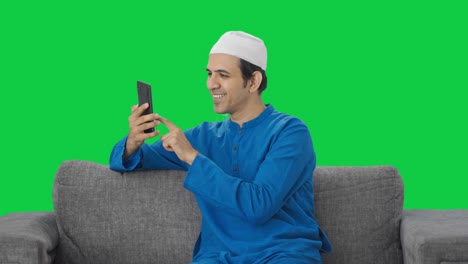 Hombre-Musulmán-Feliz-Desplazándose-Por-La-Pantalla-Verde-Del-Teléfono