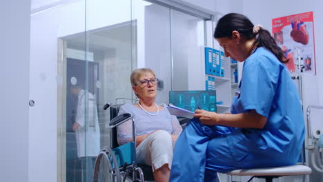 Behinderte-ältere-Frau-Im-Rollstuhl-Im-Gespräch-Mit-Krankenschwester