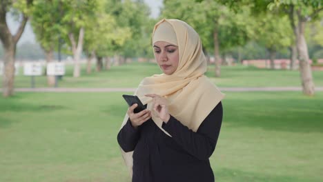 Muslimische-Frau-Benutzt-Ein-Telefon-Im-Park